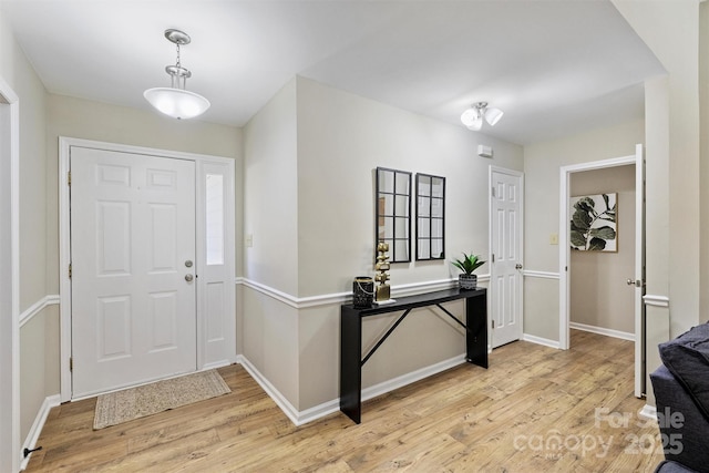 foyer entrance with baseboards and light wood finished floors