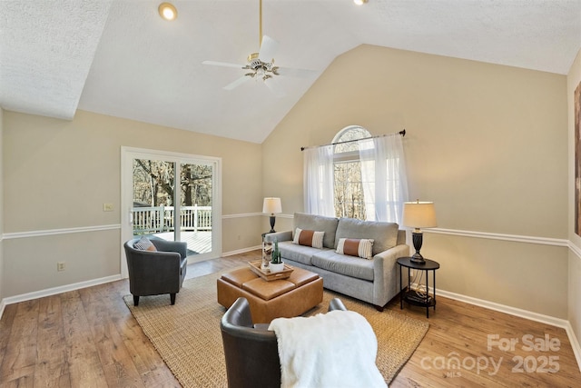 living area with baseboards and wood finished floors