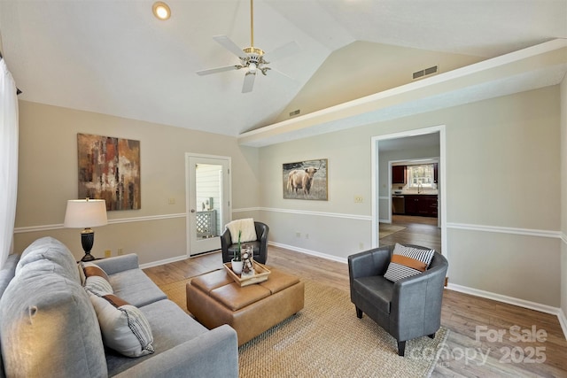 living room featuring light wood finished floors, baseboards, and visible vents