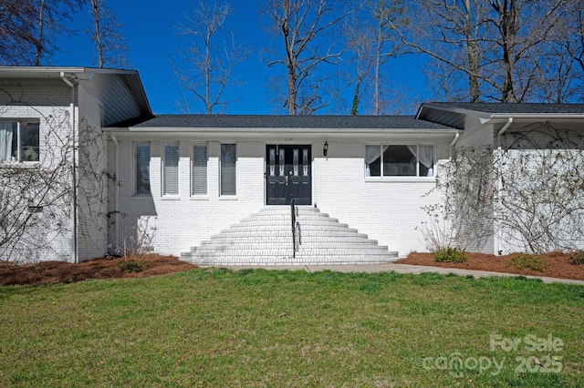 view of front of home featuring brick siding and a front yard