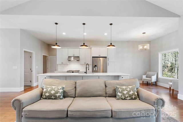 living room with recessed lighting, light wood-style flooring, and baseboards