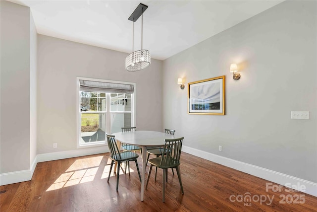 dining space featuring baseboards and wood finished floors