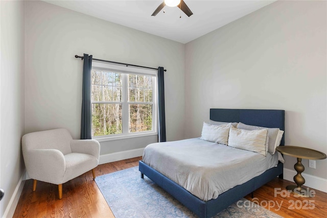 bedroom featuring a ceiling fan, baseboards, and wood finished floors