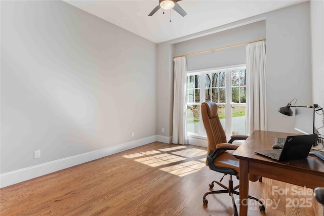 office space with light wood-style flooring, baseboards, and ceiling fan