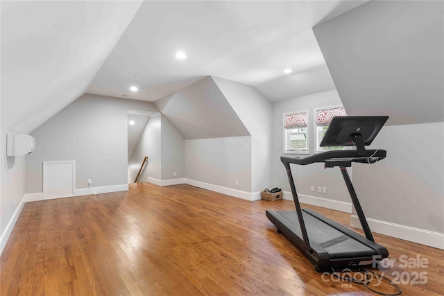 exercise room featuring vaulted ceiling, recessed lighting, wood finished floors, and baseboards