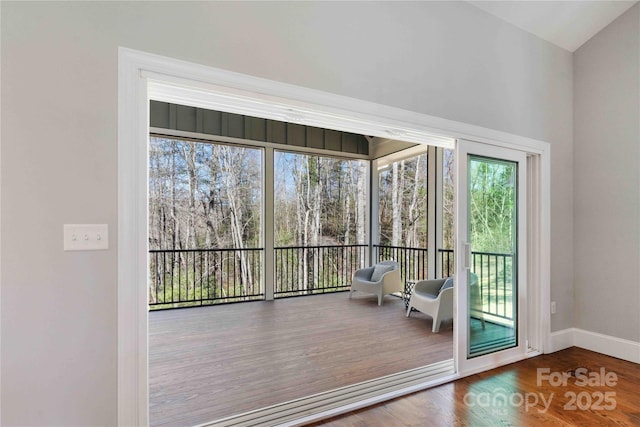 doorway featuring baseboards and wood finished floors