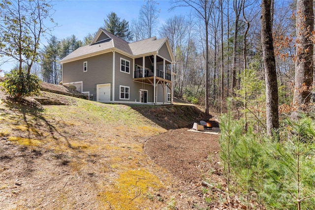 view of side of home featuring a garage and a wooded view