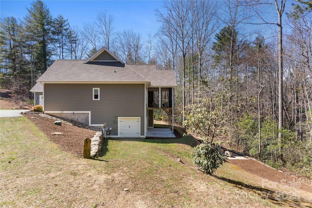 back of property featuring a garage, a yard, and driveway