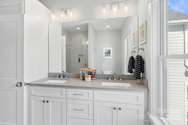 full bath featuring double vanity, toilet, a stall shower, and a sink