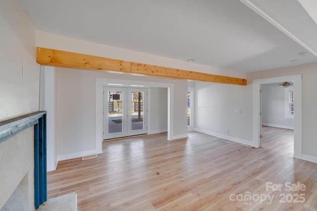 unfurnished living room with light wood-style floors, french doors, and baseboards