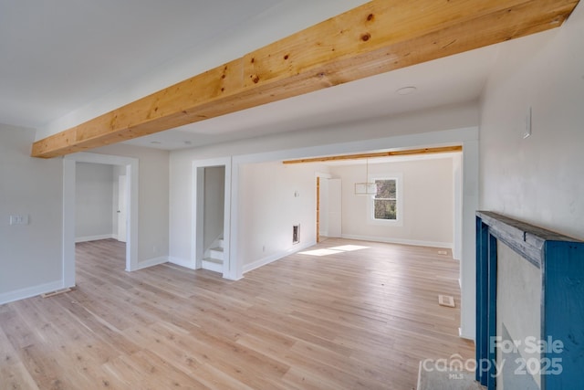 unfurnished living room with stairs, light wood finished floors, and baseboards