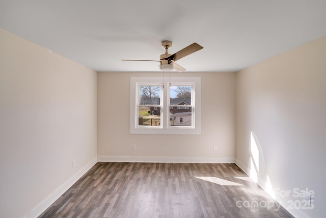 spare room featuring wood finished floors, a ceiling fan, and baseboards