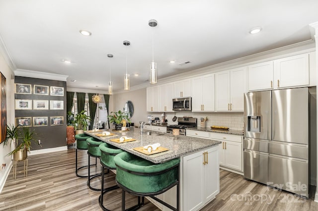 kitchen with light wood-style floors, white cabinetry, stainless steel appliances, and crown molding