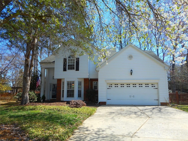 traditional home with brick siding, fence, a garage, and driveway