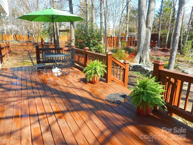 deck with outdoor dining area and fence