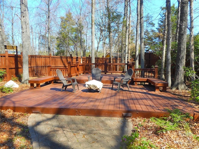 wooden terrace with a fenced backyard