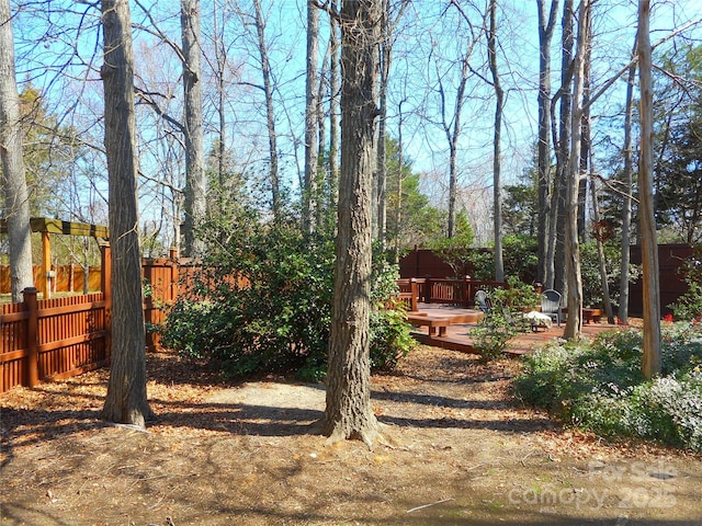 view of yard with a wooden deck and fence