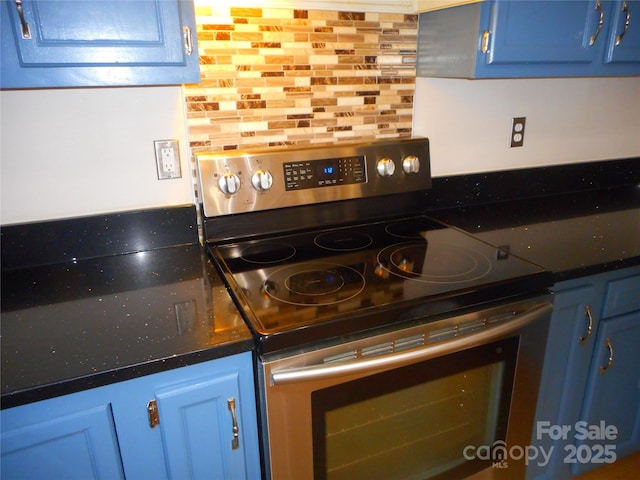 kitchen featuring blue cabinetry, dark countertops, and electric stove