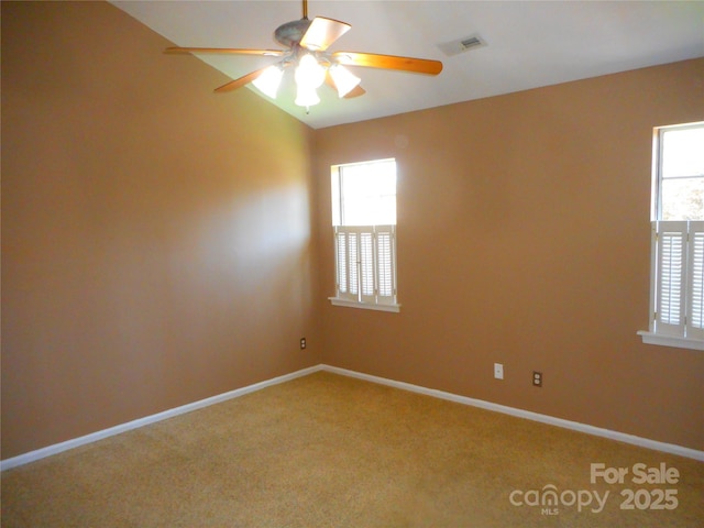 empty room with plenty of natural light, visible vents, baseboards, and carpet floors