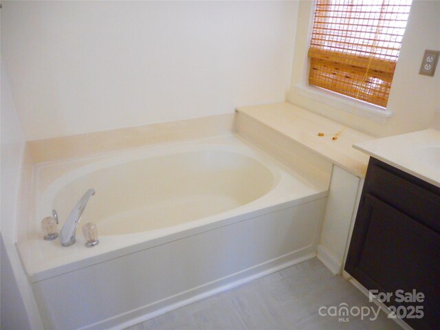 bathroom featuring vanity and a bath