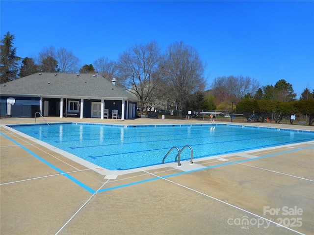 community pool with a patio and fence