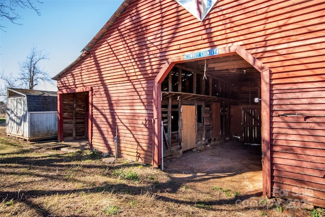 view of side of home with a storage shed and an outdoor structure