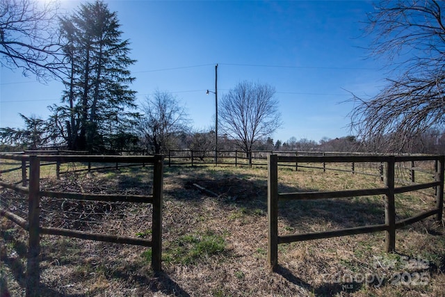 view of yard with a rural view and fence