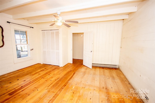 unfurnished room with a baseboard heating unit, a ceiling fan, beam ceiling, and light wood-style floors