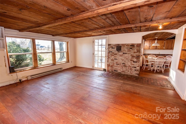 unfurnished living room featuring beam ceiling, baseboard heating, wooden ceiling, baseboards, and hardwood / wood-style flooring