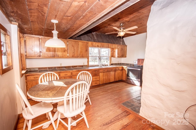 kitchen featuring wood ceiling, stainless steel electric stove, brown cabinetry, and hardwood / wood-style floors