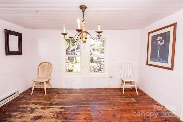 unfurnished room featuring a baseboard heating unit, an inviting chandelier, and wood finished floors