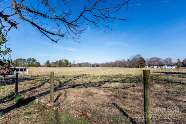 view of yard with a rural view and fence