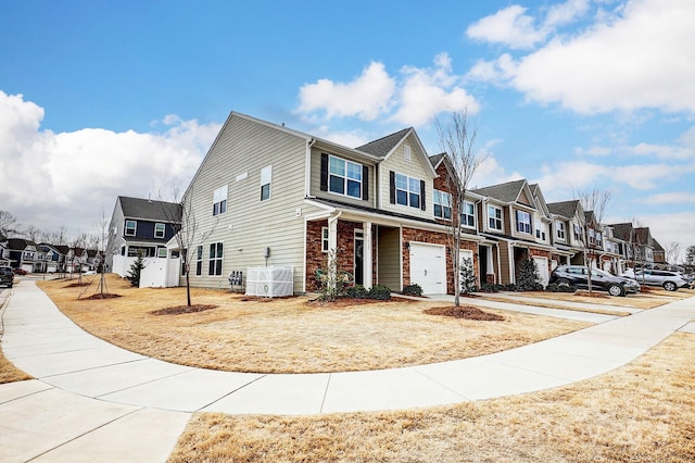 view of front of house featuring a residential view, brick siding, an attached garage, and central AC unit