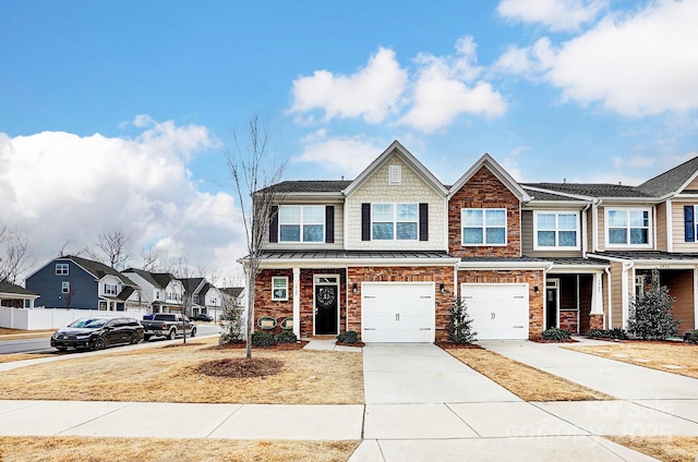 multi unit property featuring concrete driveway, brick siding, an attached garage, and a standing seam roof