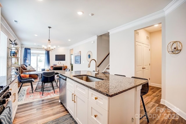 kitchen featuring stone counters, a sink, visible vents, appliances with stainless steel finishes, and light wood finished floors