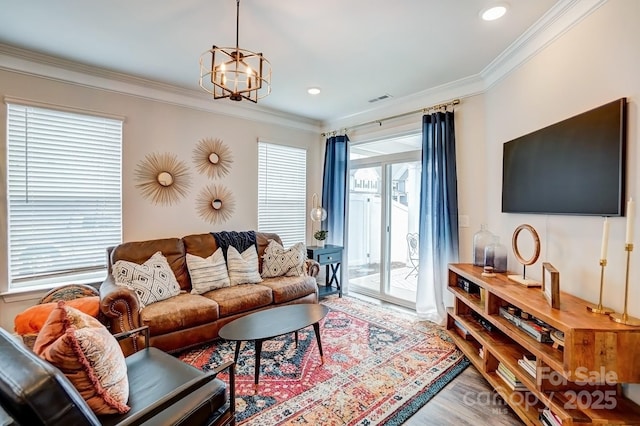 living room with crown molding, recessed lighting, visible vents, an inviting chandelier, and wood finished floors