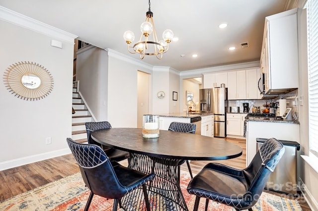 dining space with light wood-style floors, baseboards, stairway, and ornamental molding