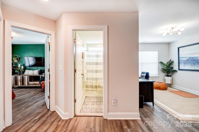 hallway with wood finished floors and baseboards