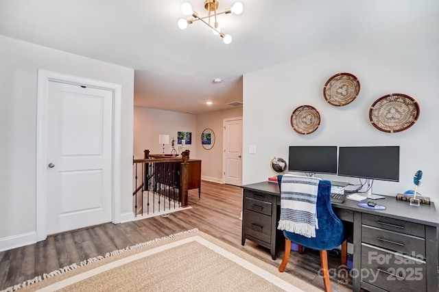 office with an inviting chandelier, visible vents, baseboards, and wood finished floors