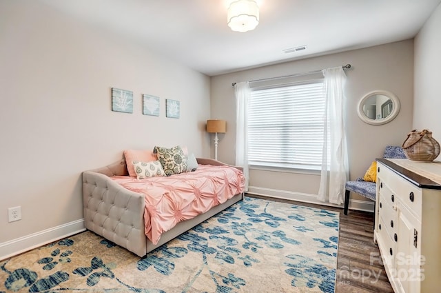 bedroom featuring baseboards, visible vents, and wood finished floors