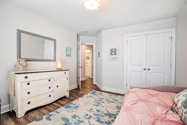 bedroom with baseboards, dark wood finished floors, and a closet