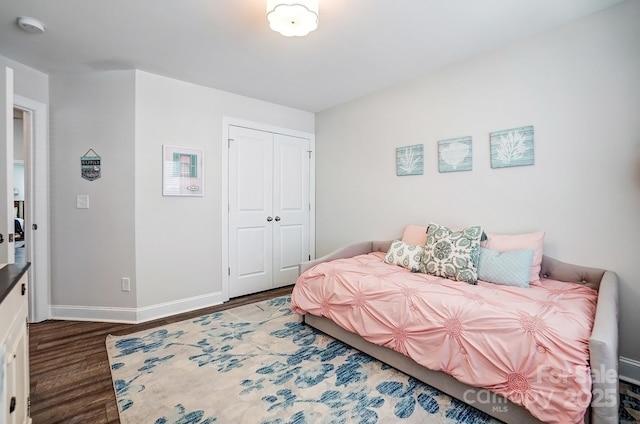 bedroom with a closet, baseboards, and wood finished floors