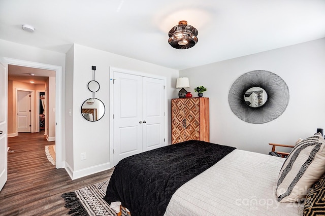 bedroom with a closet, baseboards, and wood finished floors