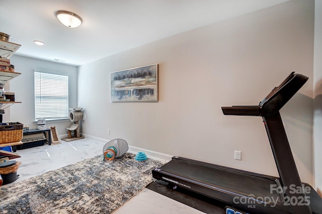 workout room featuring marble finish floor and baseboards