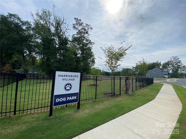 view of home's community with fence and a lawn