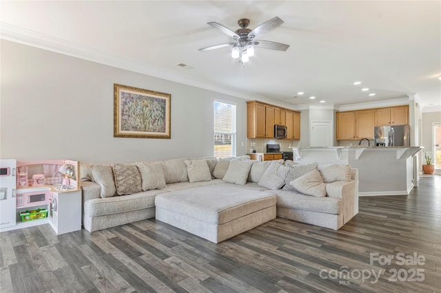 living room with visible vents, a ceiling fan, ornamental molding, dark wood-style flooring, and recessed lighting