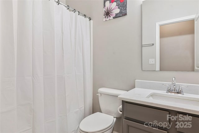 bathroom featuring a shower with shower curtain, vanity, and toilet