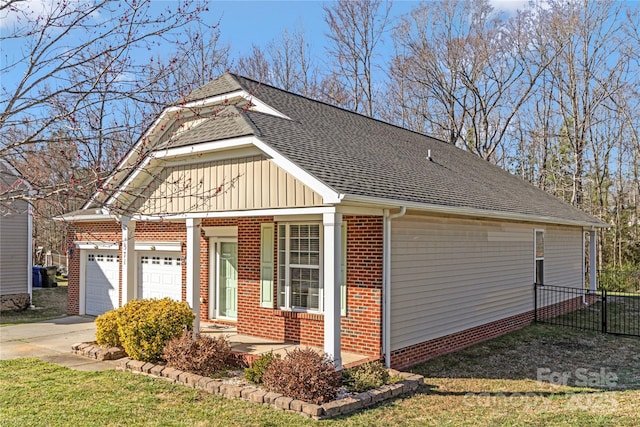 view of side of property featuring driveway, roof with shingles, an attached garage, board and batten siding, and brick siding