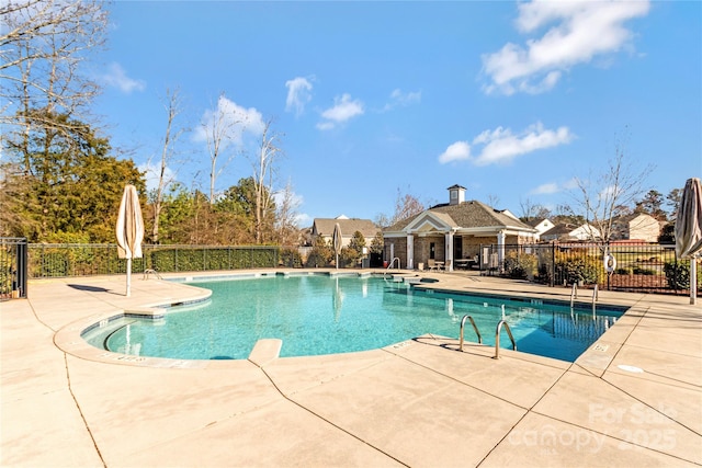 community pool with fence and a patio