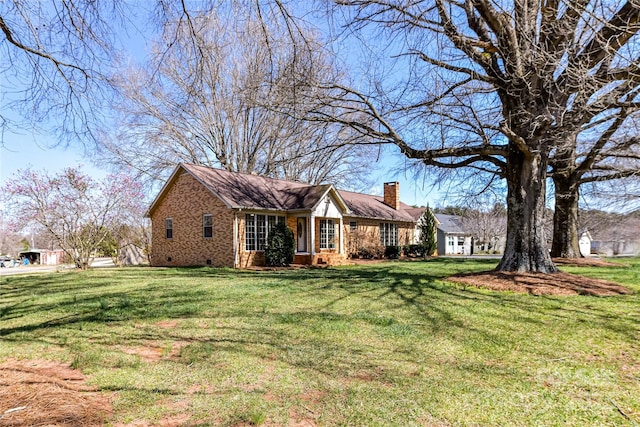 single story home featuring crawl space, a chimney, brick siding, and a front yard